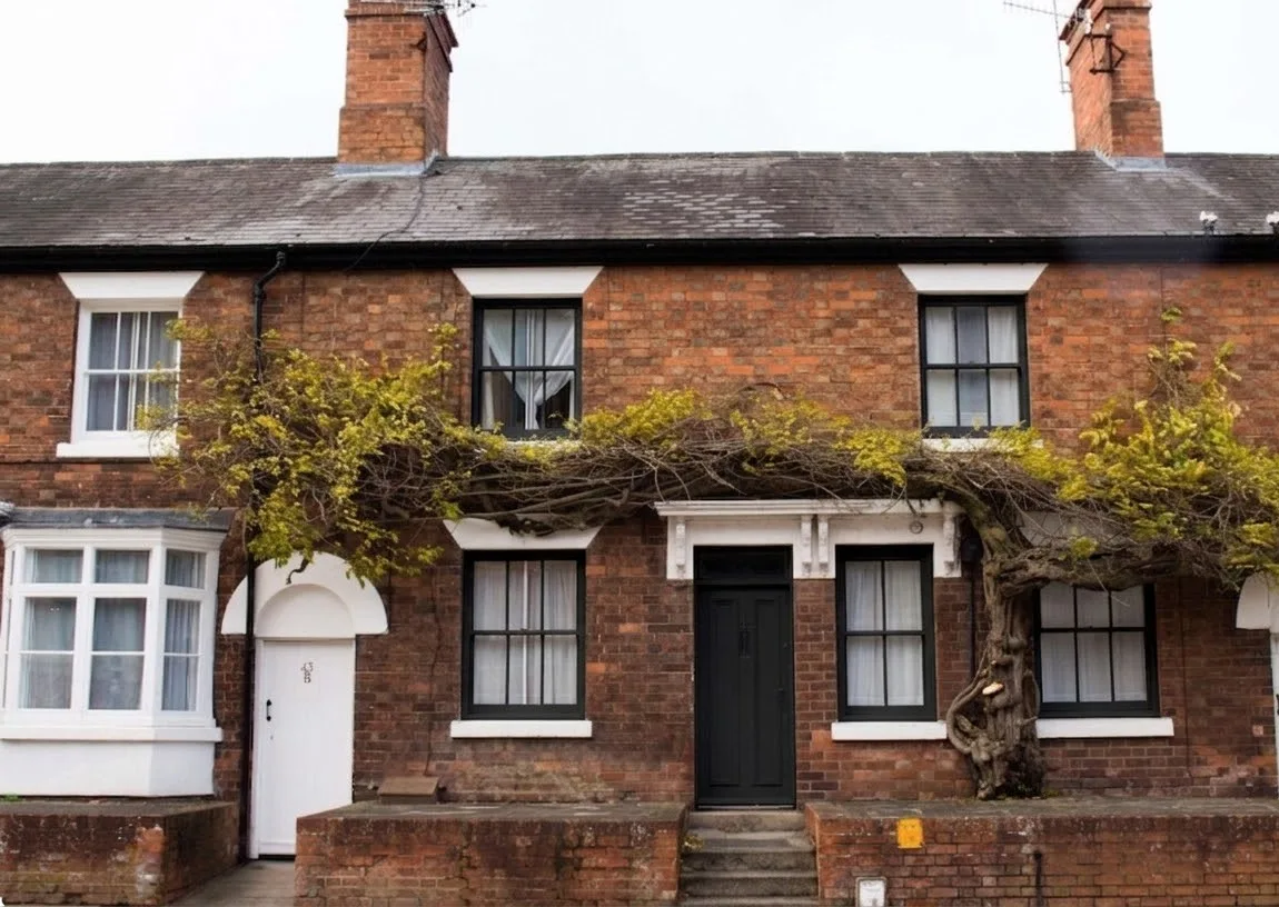 The same terraced house visualised by Unformed with black aluminium windows and a black front door, matched to the AluK 58ST system